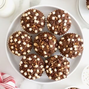 Seven rocky road brownie cupcakes on a white platter.
