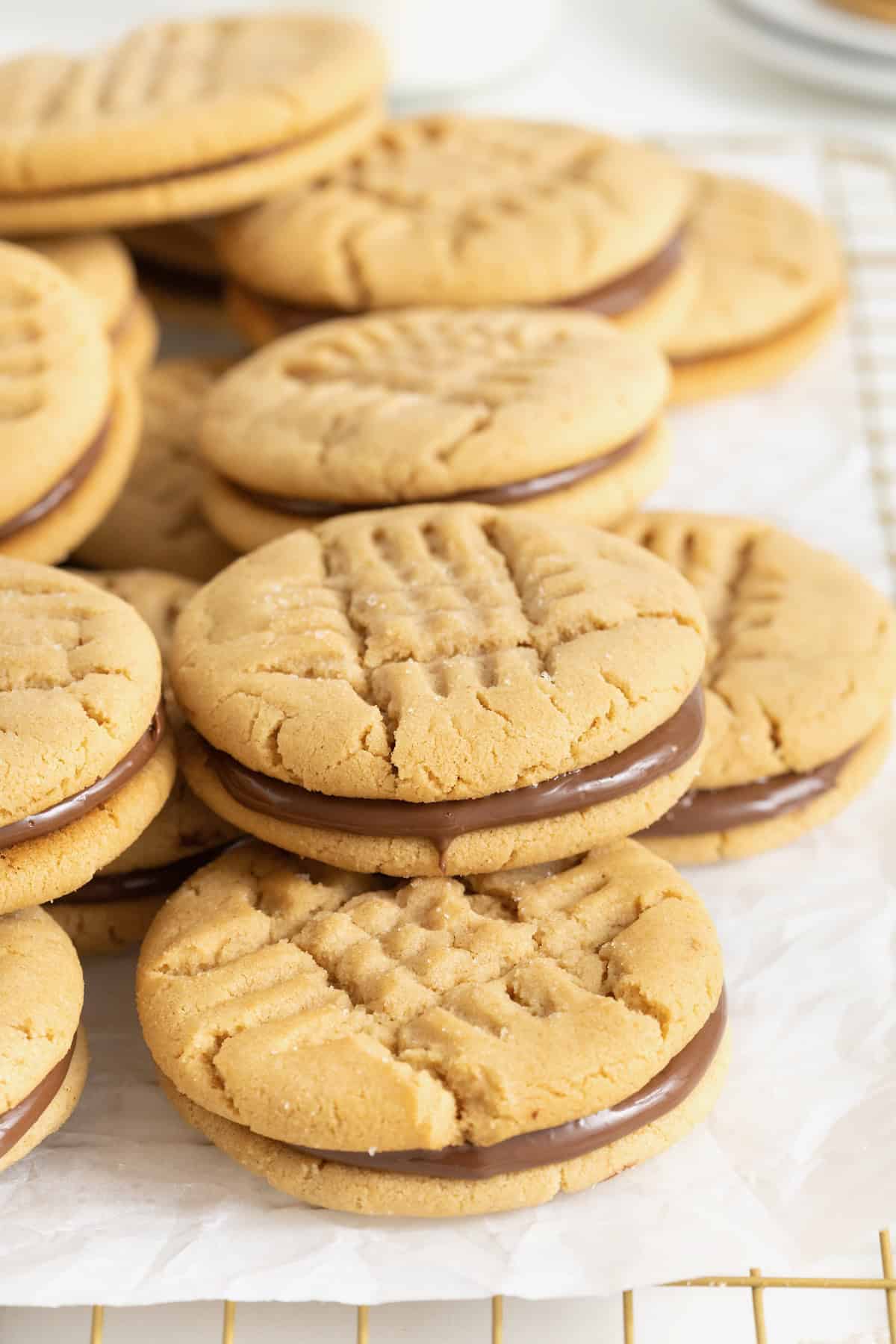A pile of peanut butter cookie sandwiches with Nutella in the middle.