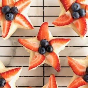 Star shaped shortbread cookies with strawberry slices and blueberries in the center.