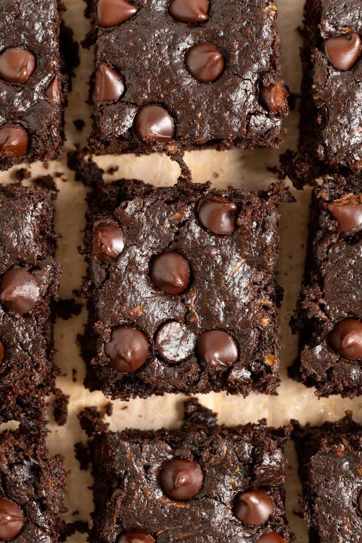 Dark chocolate zucchini brownies on a light wood cutting board of brownies.