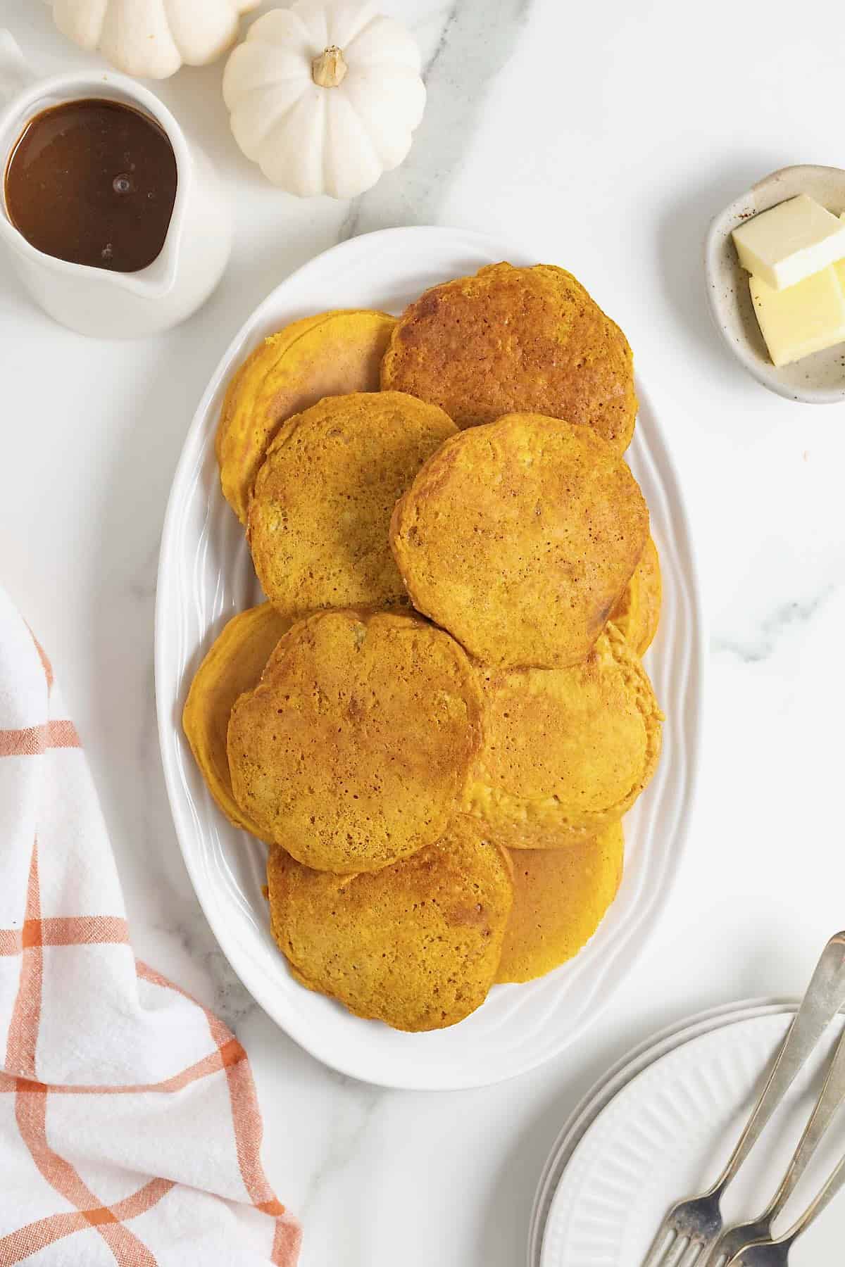 A white oblong plate of pumpkin banana pancakes.