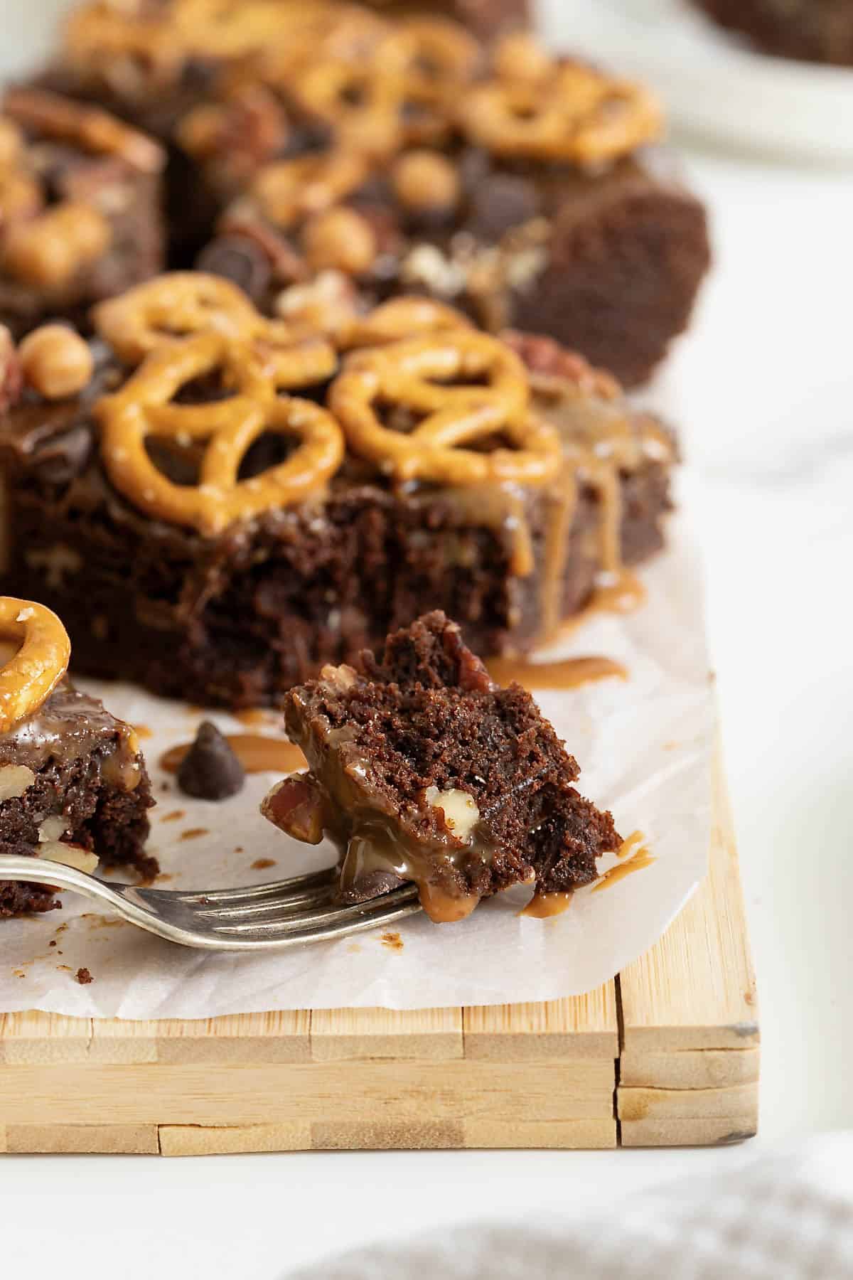 A single bite cut out of a brownie with a metal fork.