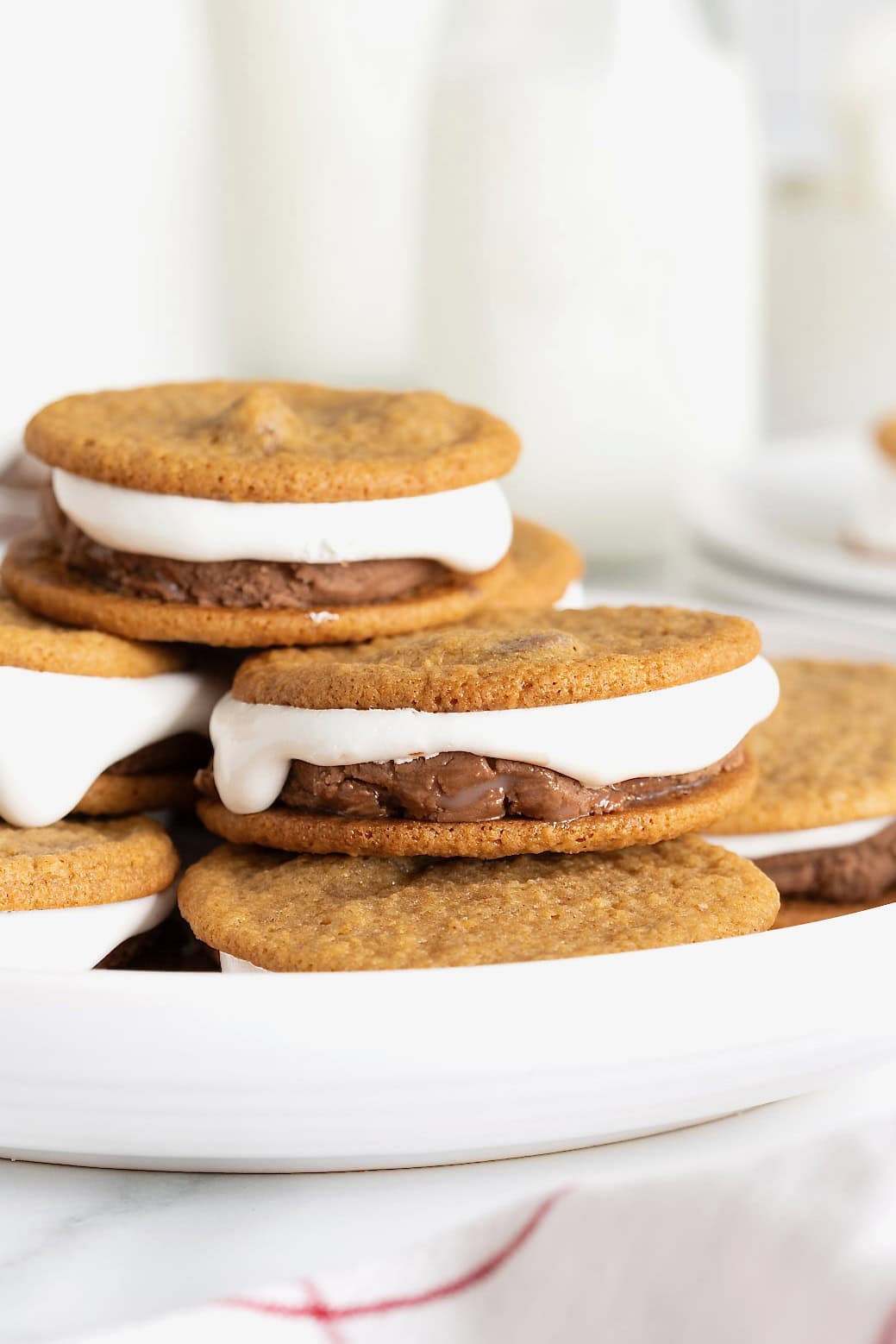 S'mores ice cream sandwiches piled on a rimmed white serving platter.
