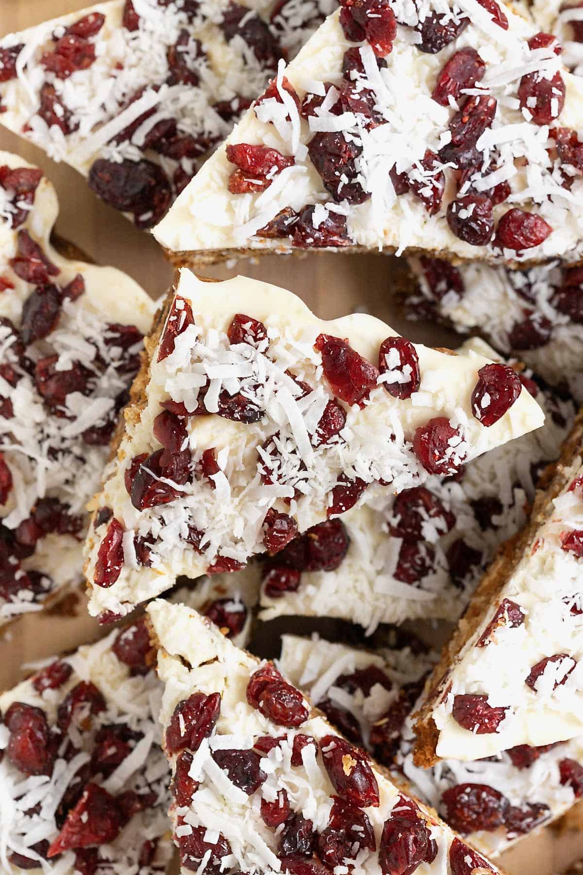 Cranberry coconut cranberry cookie bars piled on a cutting board.