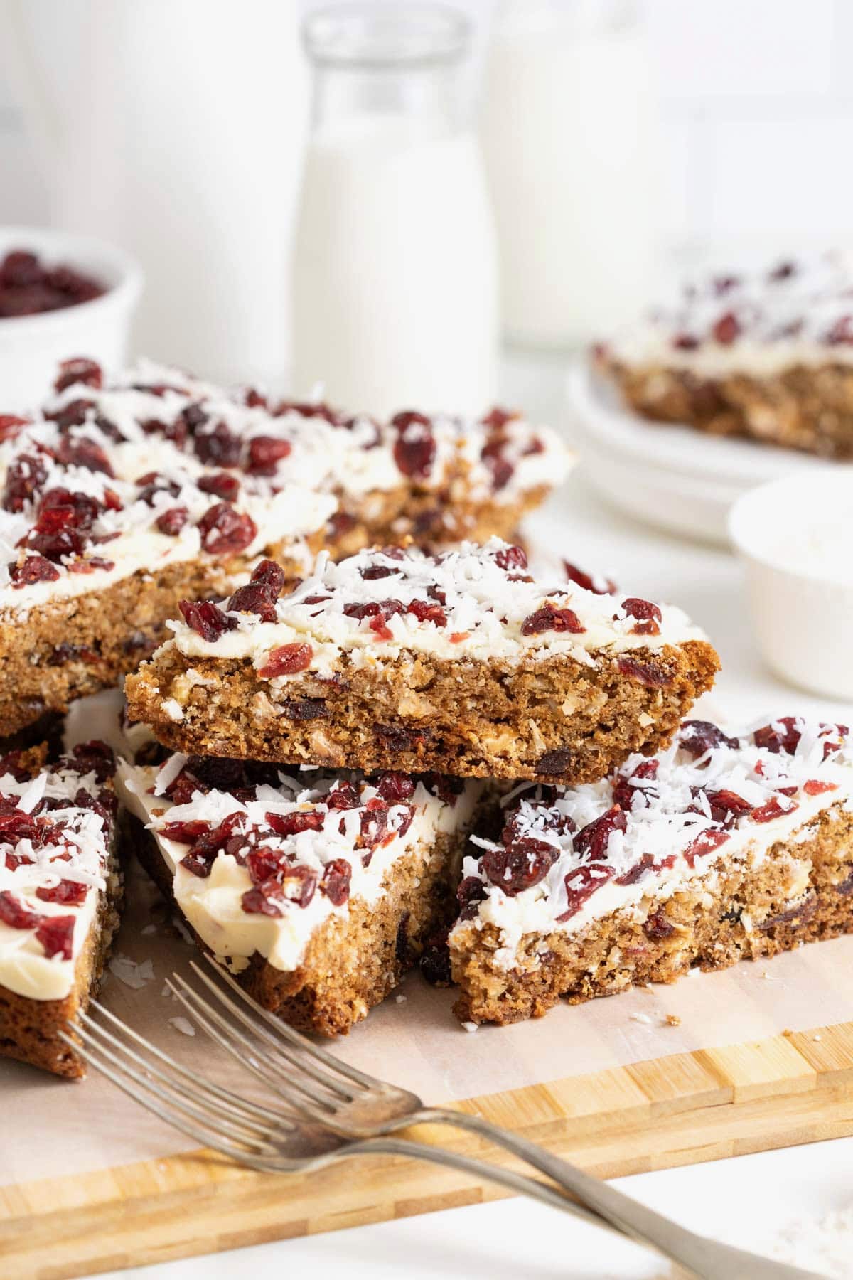 Cranberry coconut cranberry cookie bars piled on a cutting board.