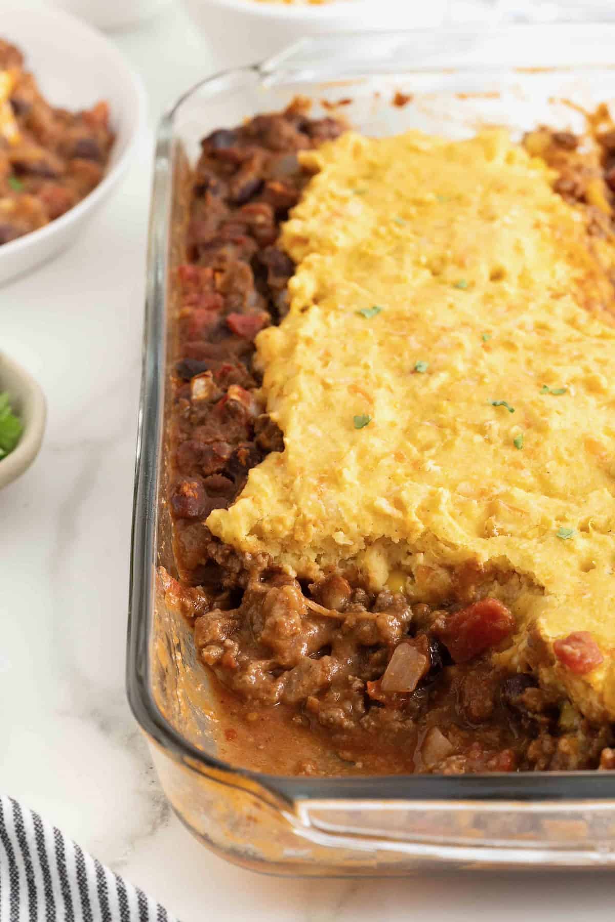 Chili Cornbread Casserole in a glass baking dish on a white counter.