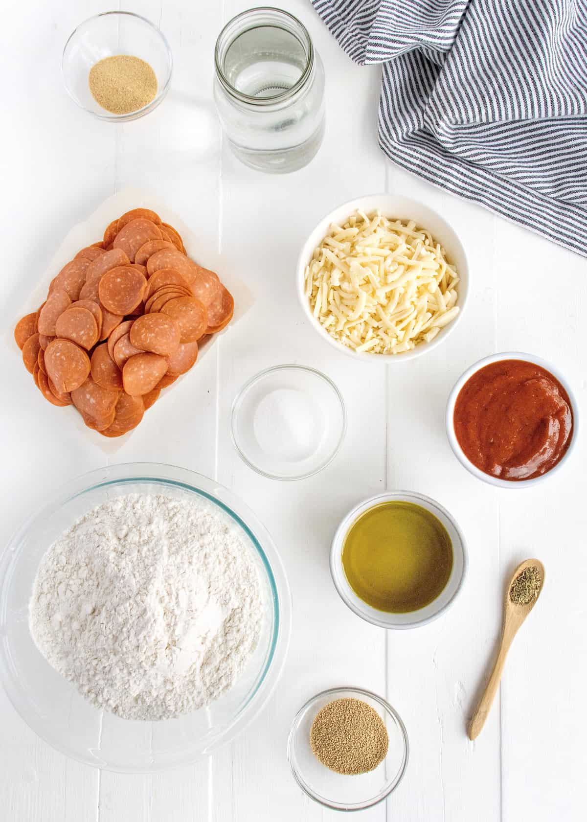 Ingredients to make a sheet pan pizza arranged on a counter.