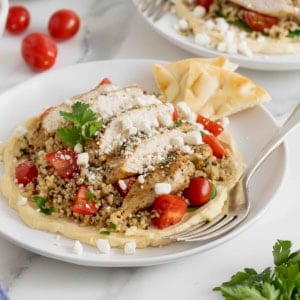 A hummus and quinoa salad with chicken, tomatoes and feta.