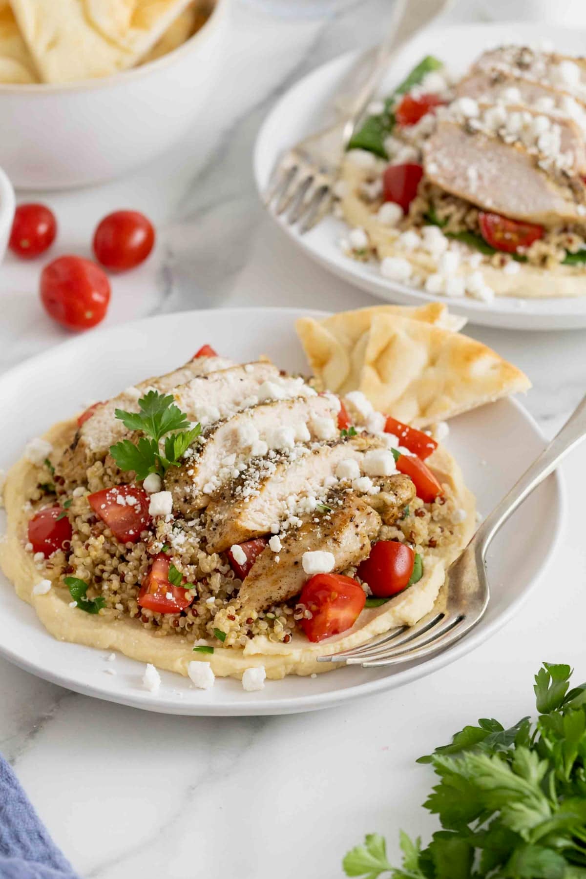 A hummus and quinoa salad with chicken, tomatoes and feta. 