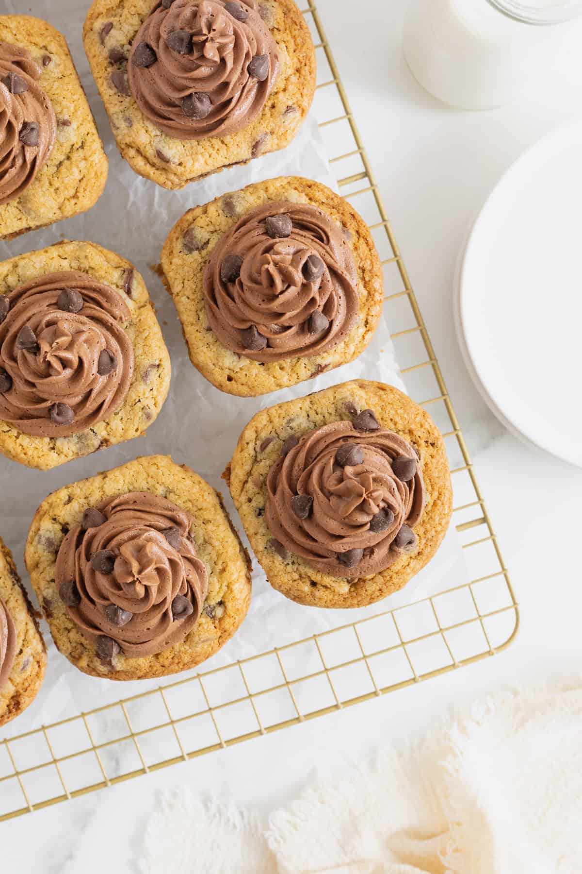 Twelve cookie cup cupcakes frosted with chocolate frosting and garnished with chocolate chips.