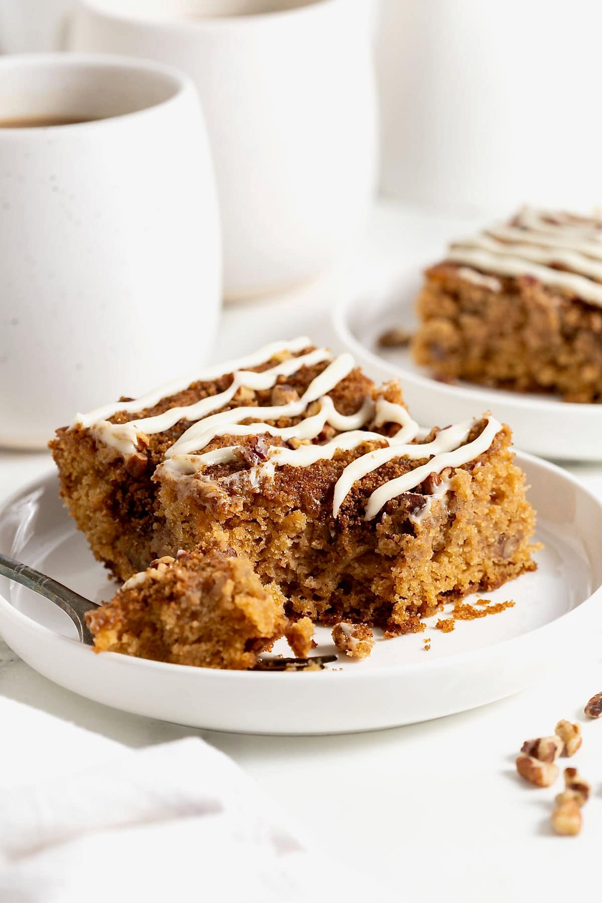 A slice of cream cheese coffee cake on a white rimmed plate.