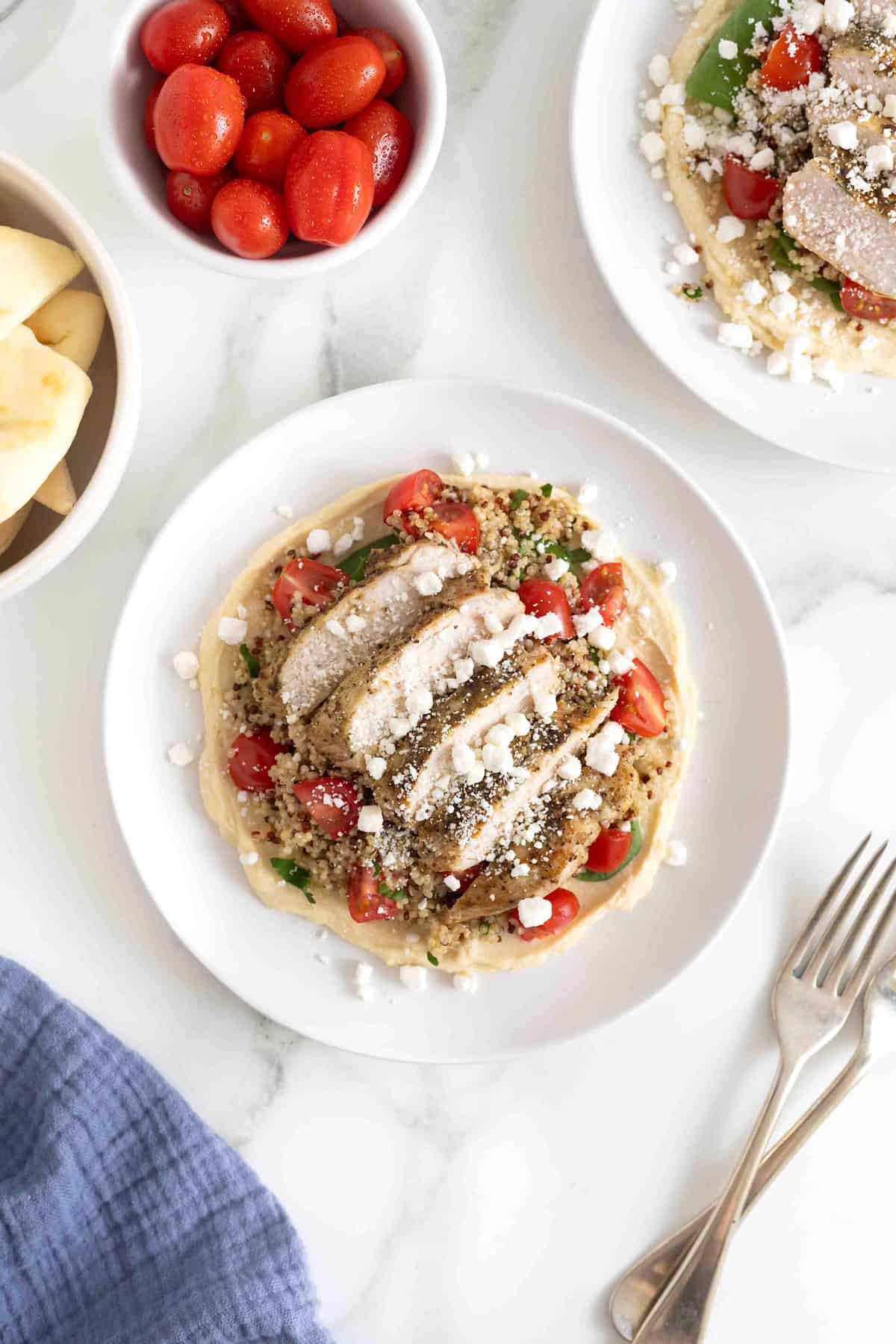 A hummus and quinoa salad with chicken, tomatoes and feta.