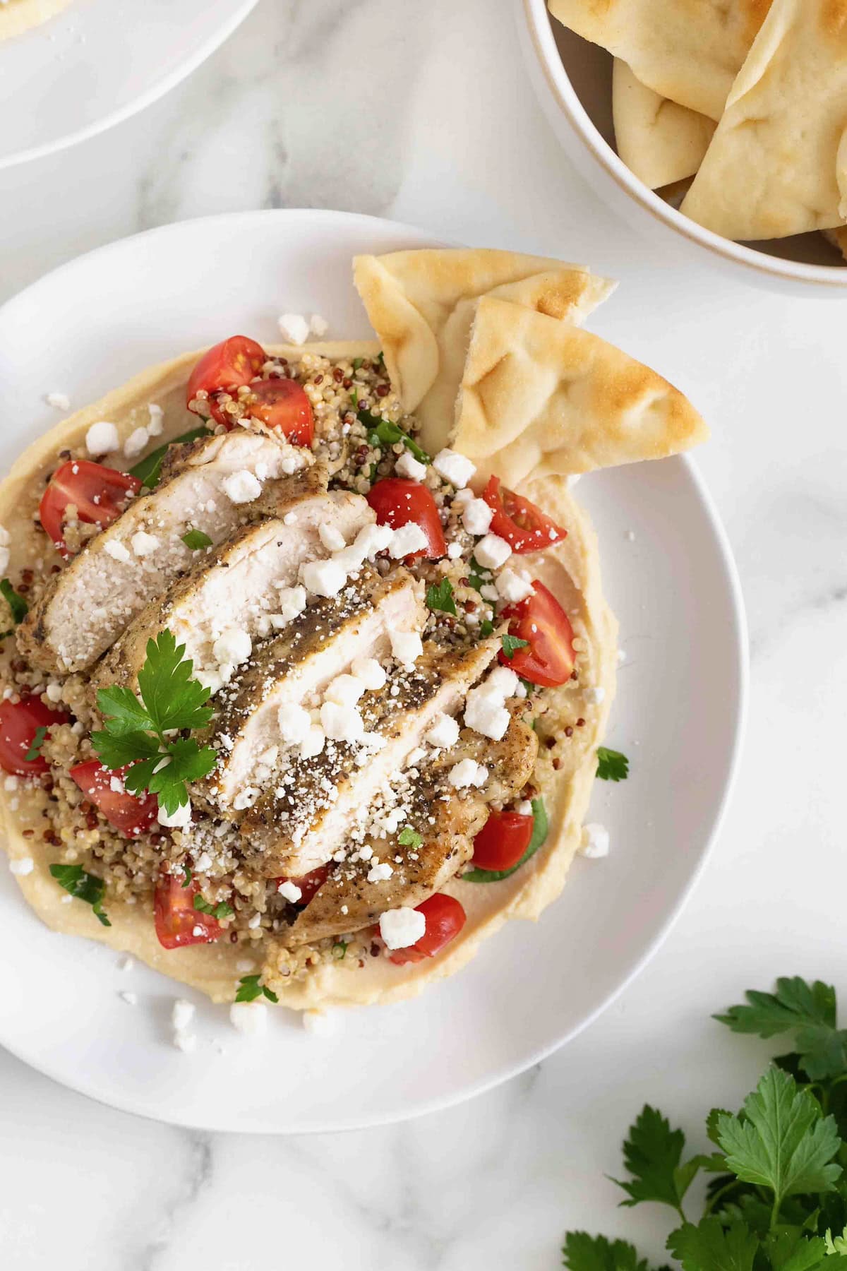 A hummus and quinoa salad with chicken, tomatoes and feta.