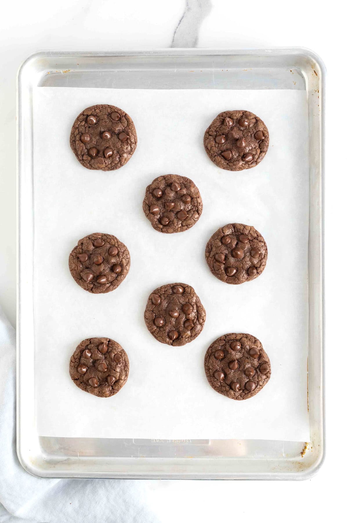 Double chocolate cookies on a parchment lined cooling rack.