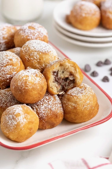 A white ceramic serving tray with a red border filled with fried cookie dough.