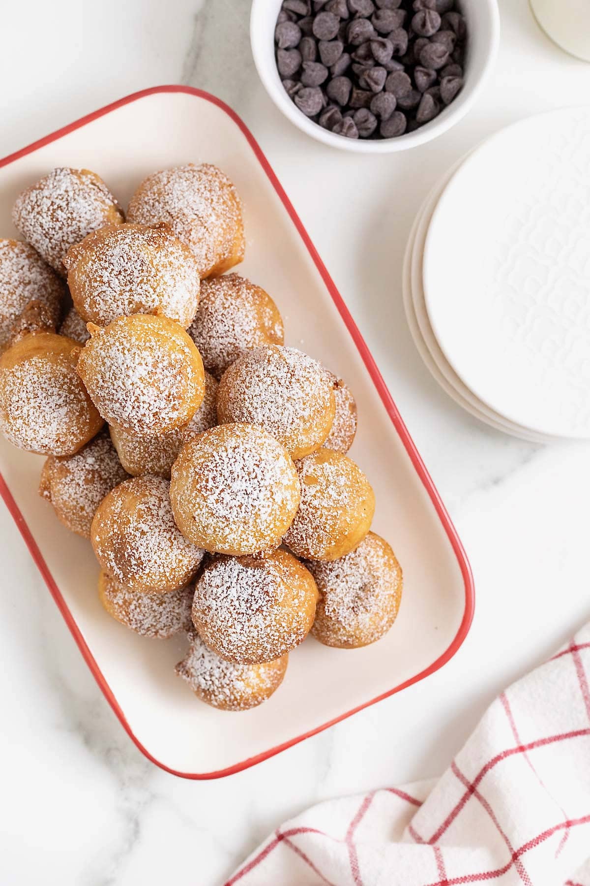 A white ceramic serving tray with a red border filled with fried cookie dough.