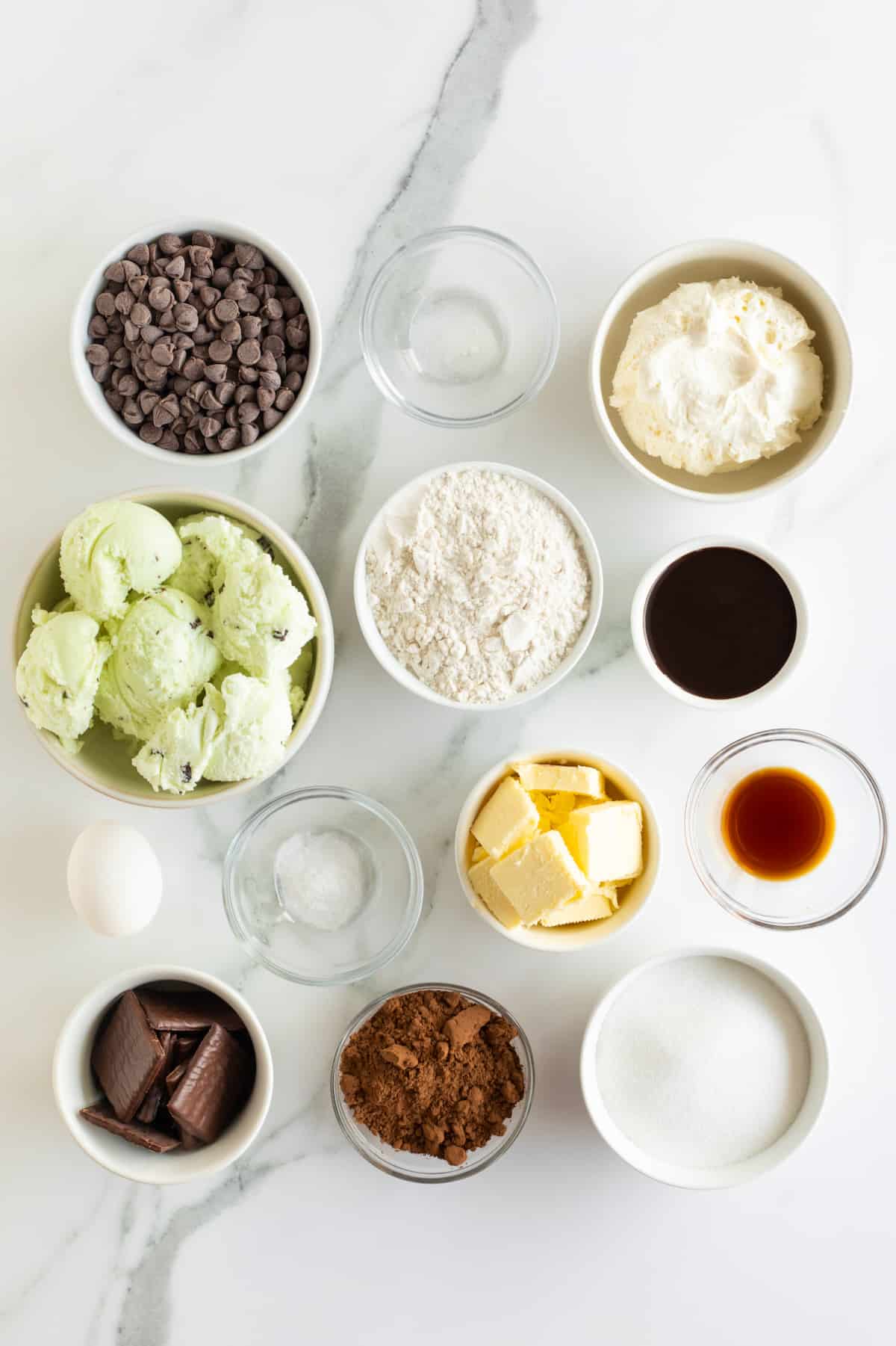 Mint chocolate chip ice cream, butter, vanilla extract, flour, Cool Whip, Andes Mints, cocoa powder in small dishes.