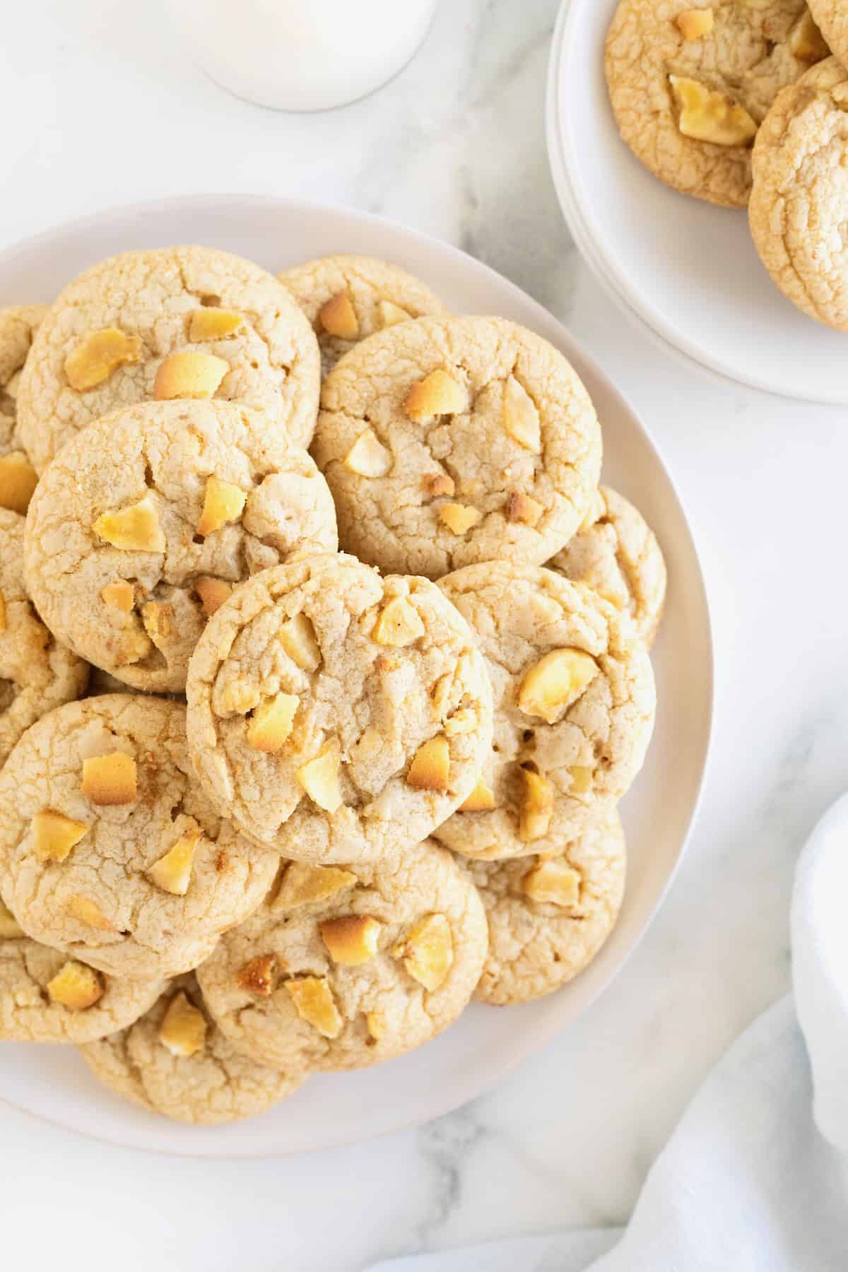 A large white serving platter stacked with banana pudding cookies with chunks of dried banana and Nilla wafers visible in the cookies.