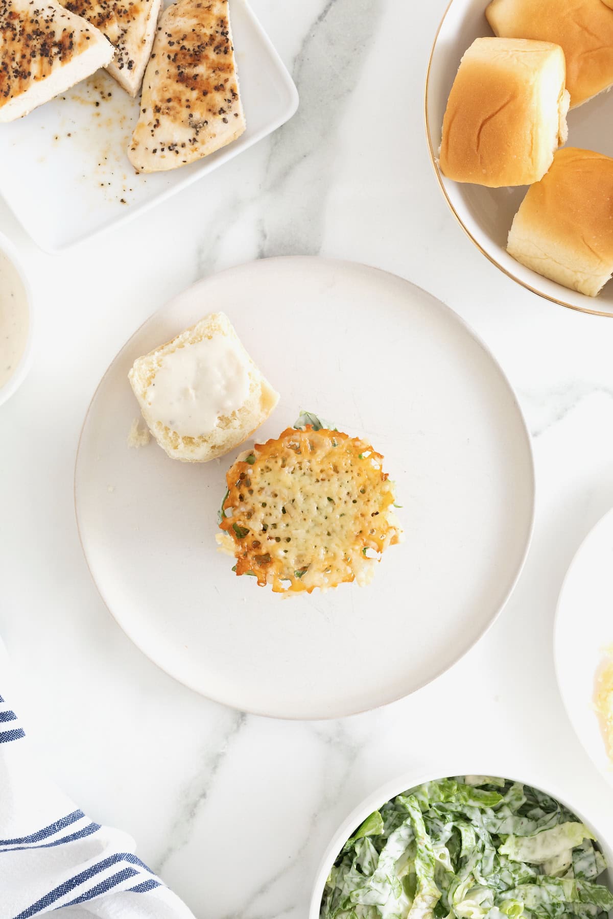 A parmesan crisp on a grilled chicken caesar slider.