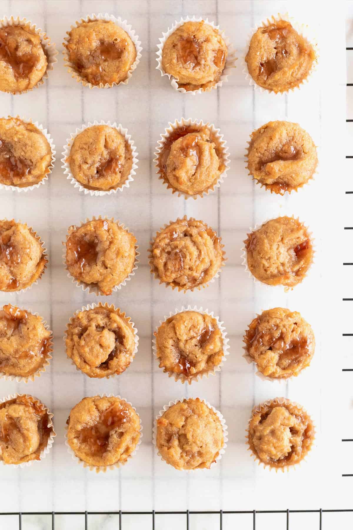 Mini Peanut butter and jelly muffins on a parchment lined cooling rack.