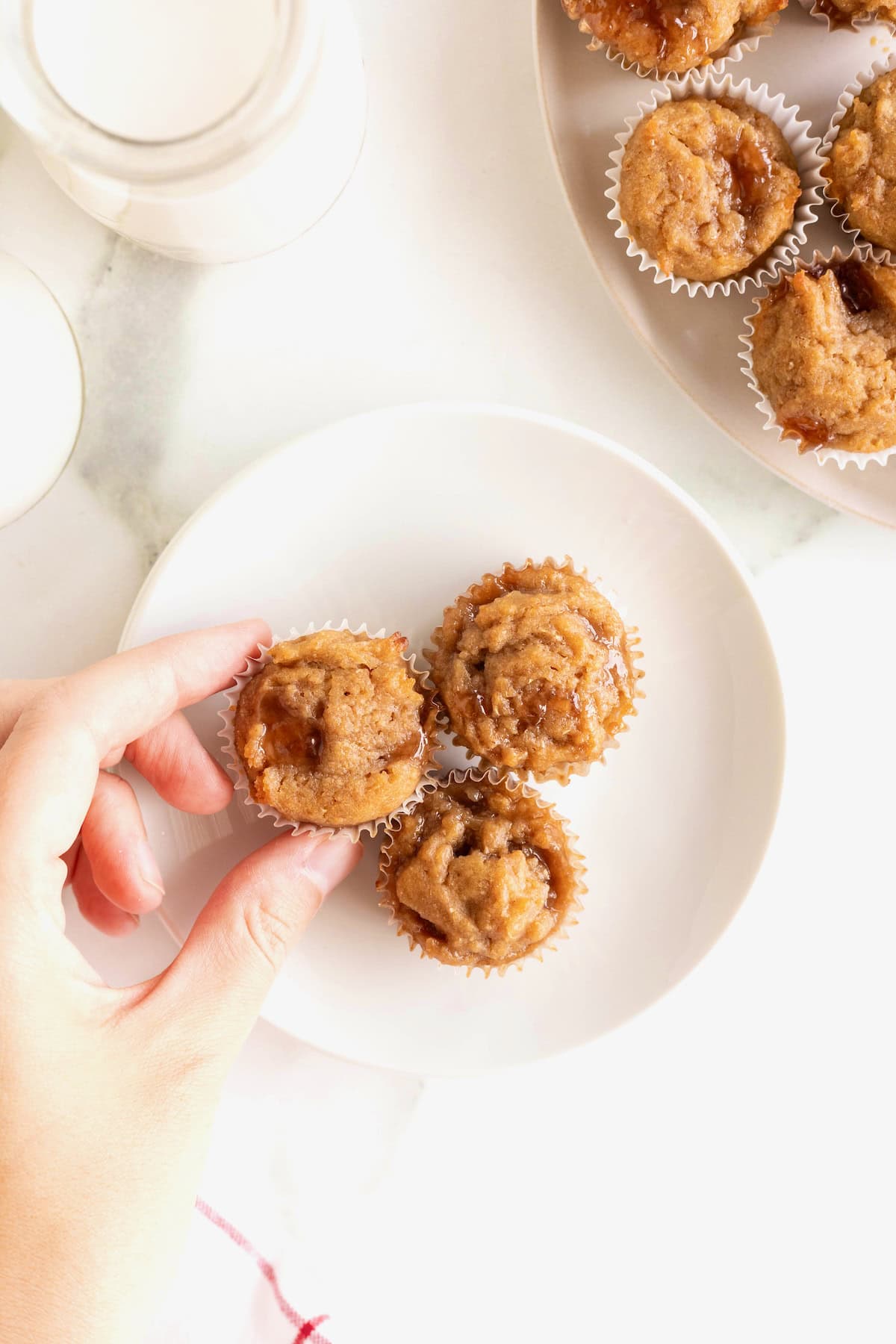 A small white plate with three peanut butter and jelly mini muffins.