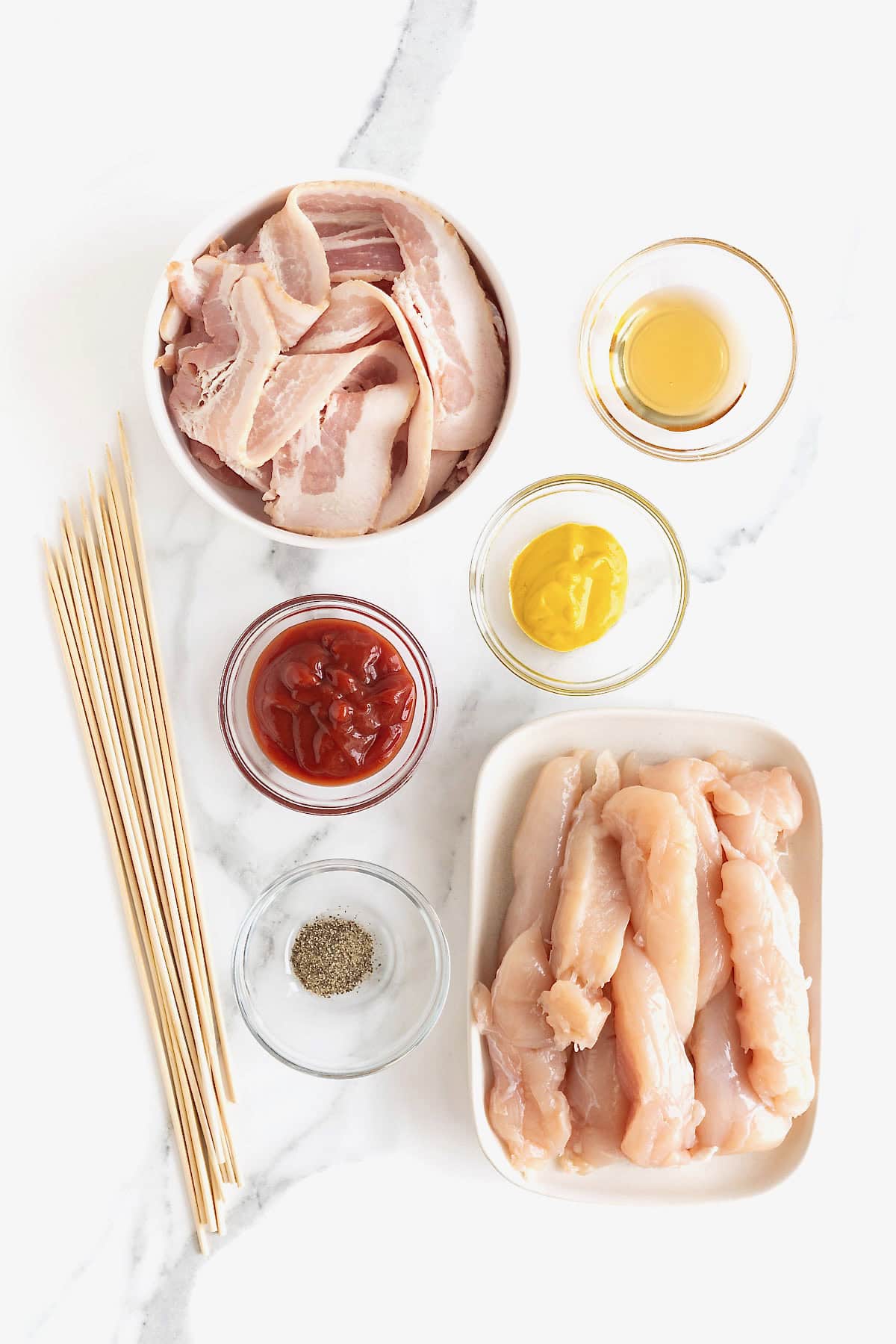 Ingredients to make grilled chicken skewers wrapped in bacon.