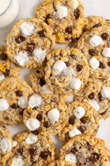A pile of corn flake cookies with chocolate chips, mini marshmallows and coconut.