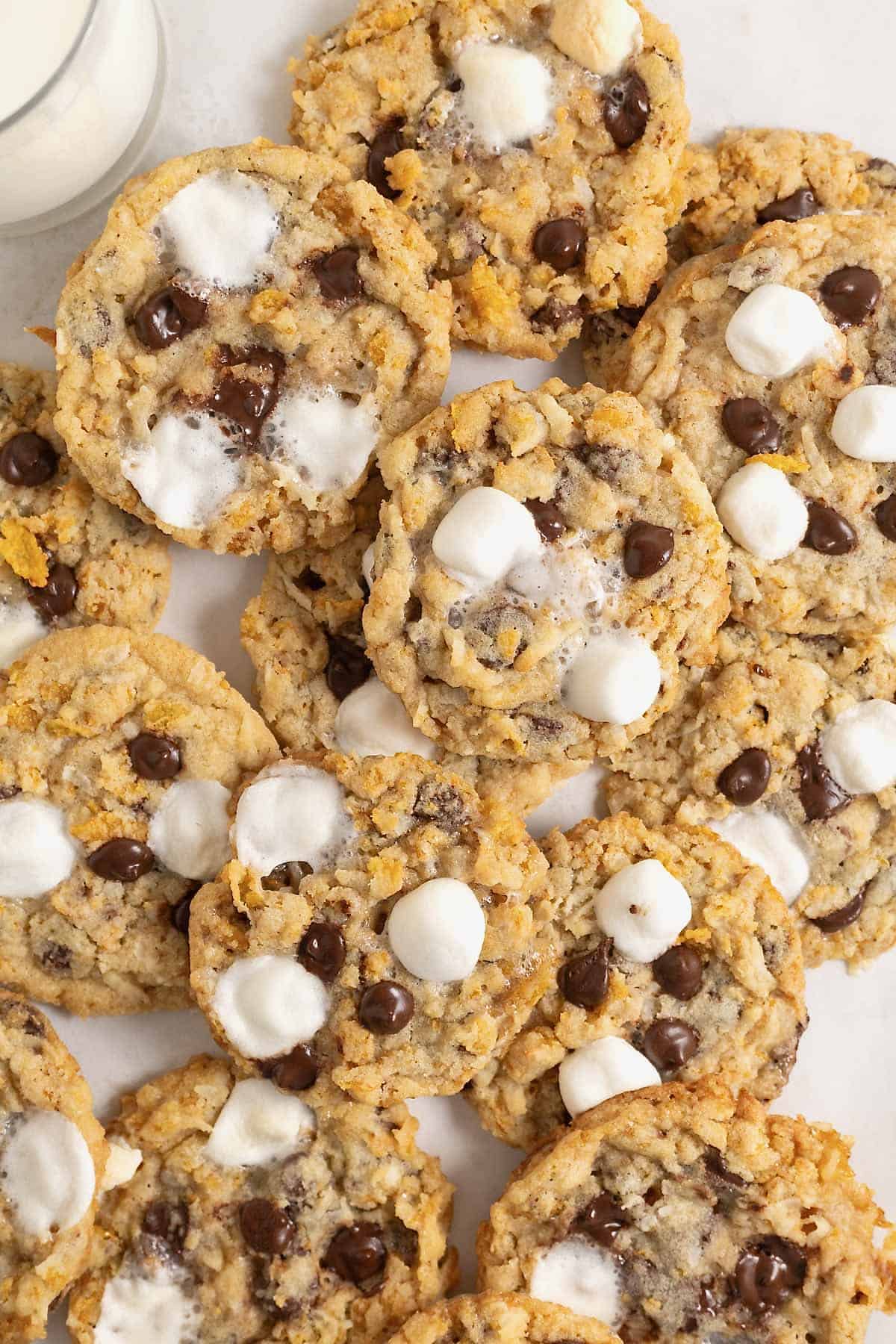 A pile of corn flake cookies with chocolate chips, mini marshmallows and coconut.