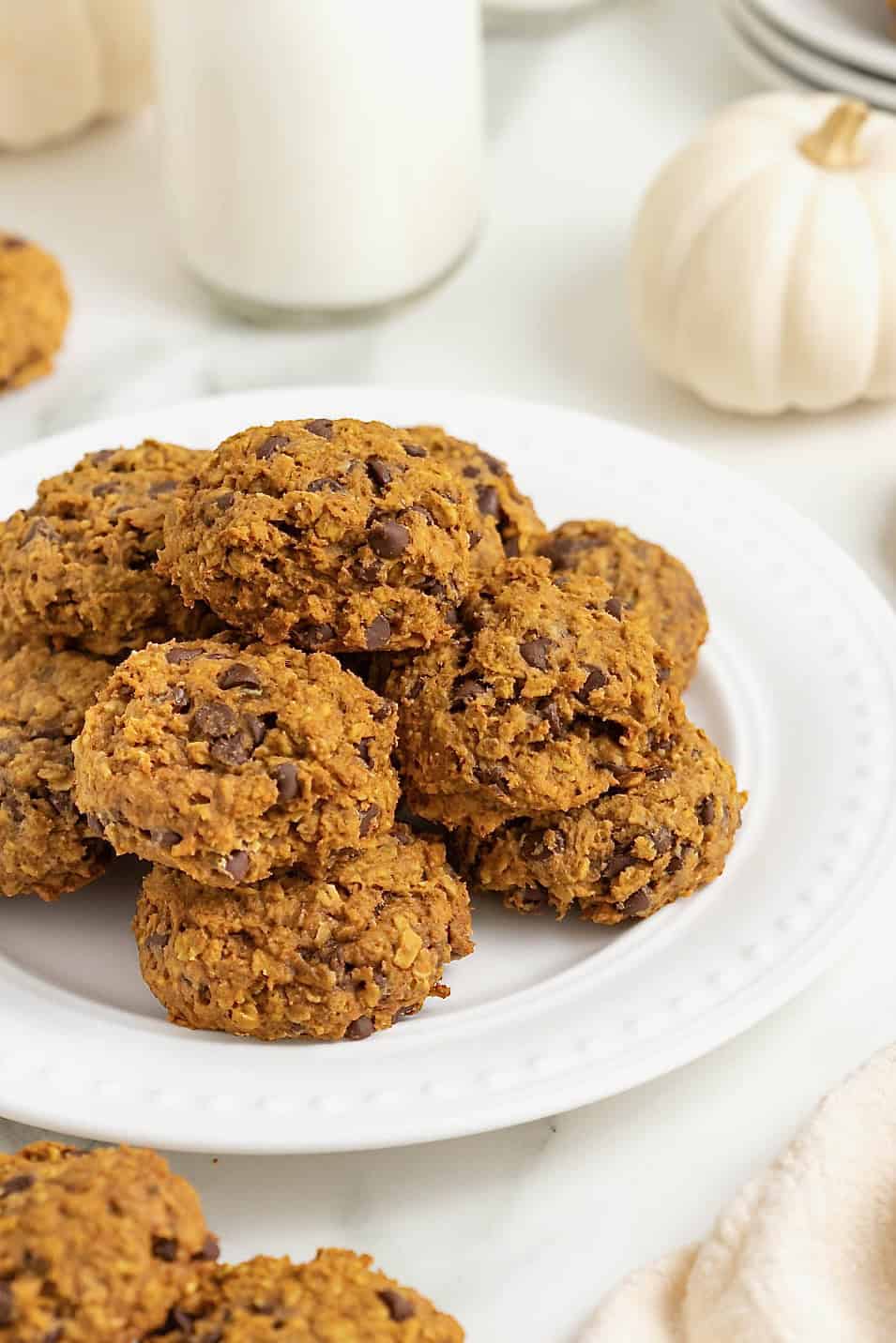 A white round serving platter of mini pumpkin chocolate chip oatmeal cookies.