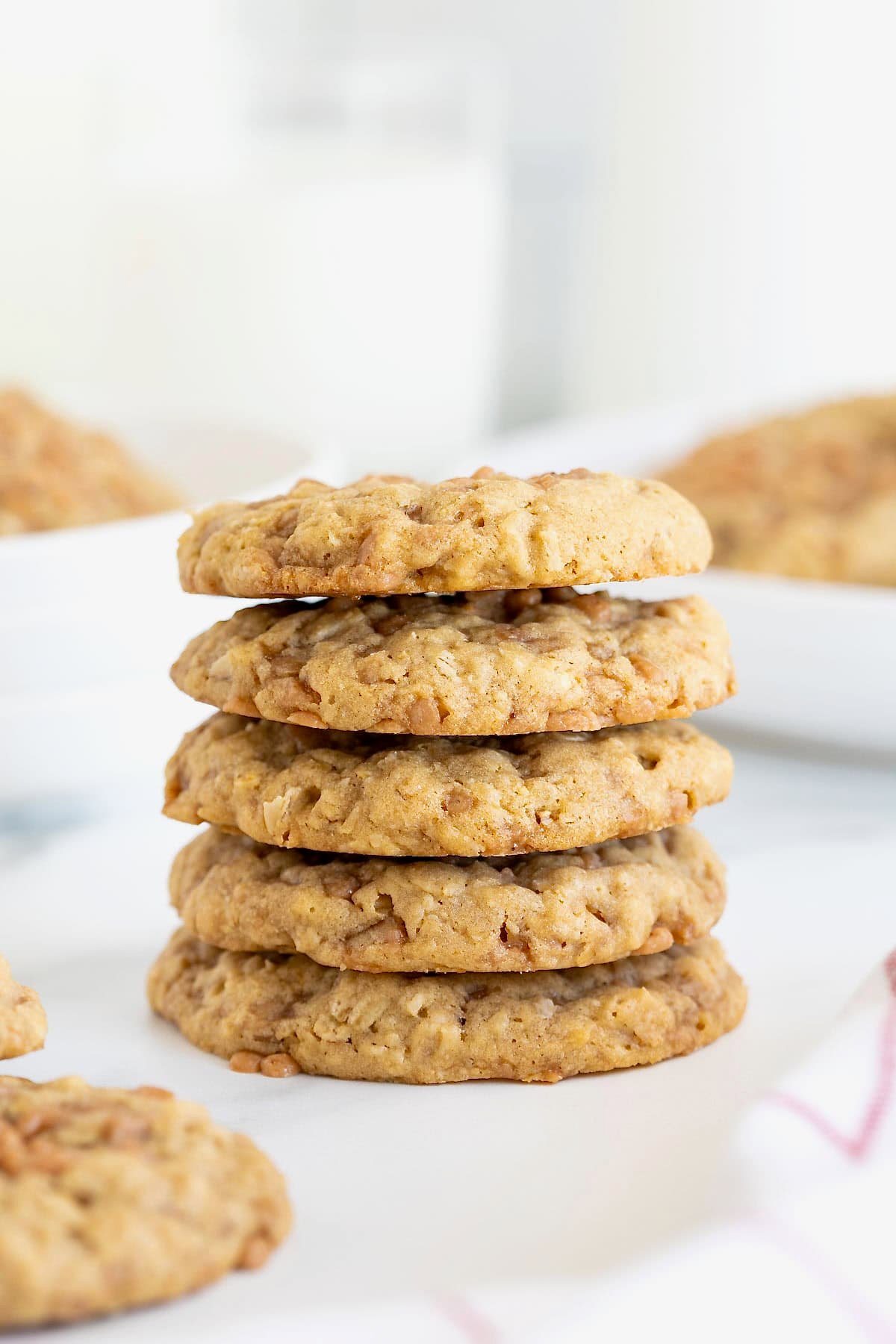 A stack of five oatmeal toffee crunch cookies on a white marble counter. 