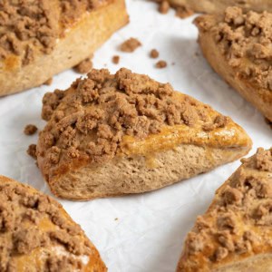Seven snickerdoodle streusel scones on a white surface.