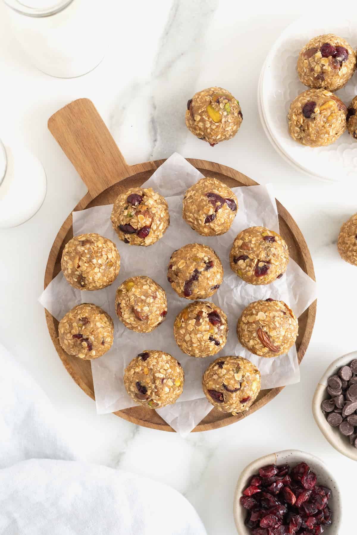 Trail mix bites on a sheet of parchment paper on a wooden platter.