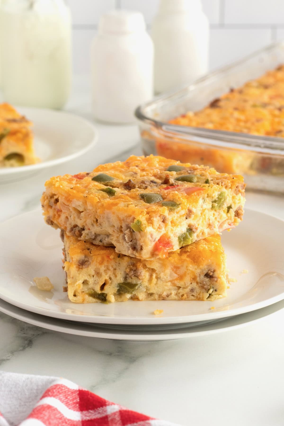Two pieces of breakfast bake stacked on a white plate.