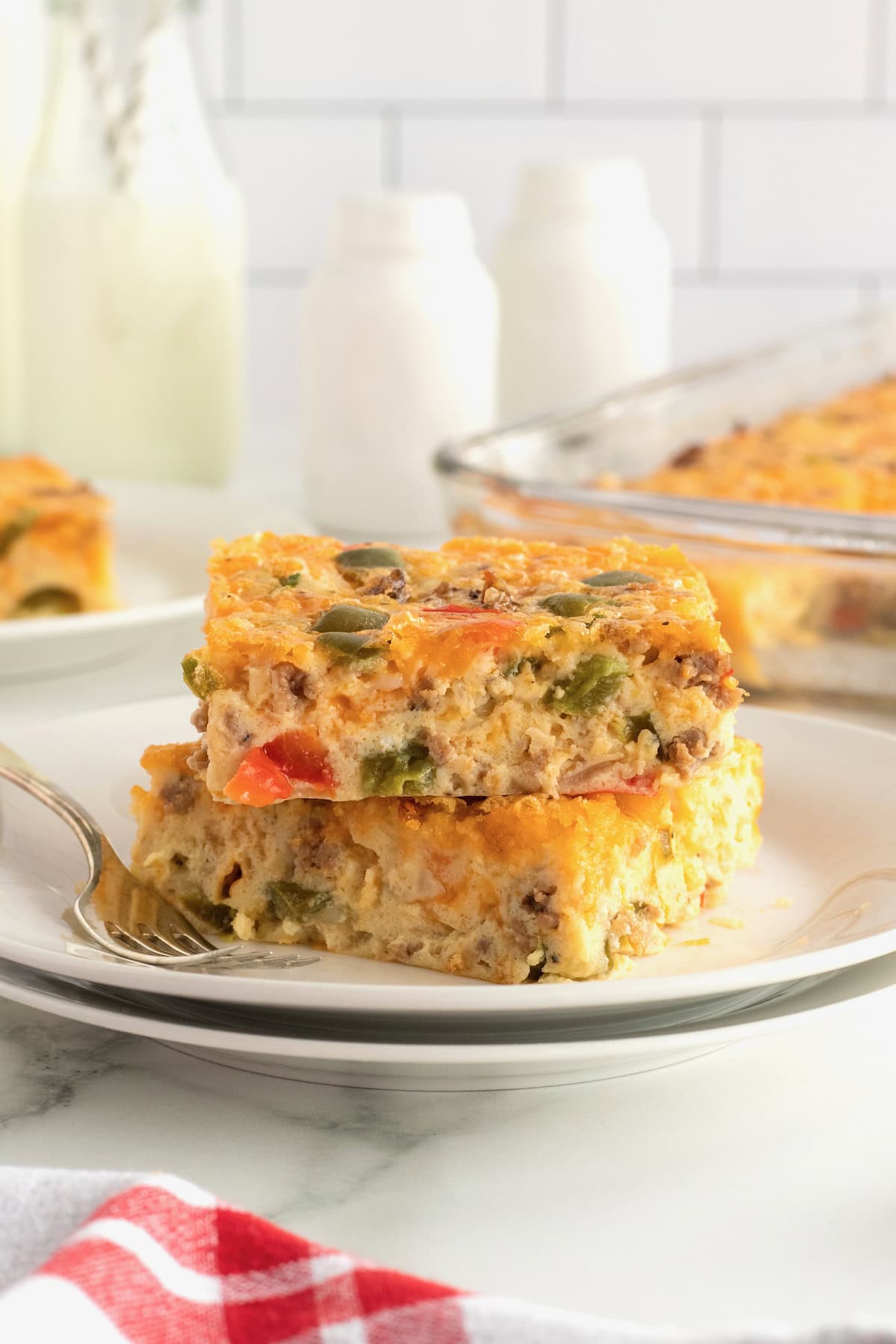 Two pieces of breakfast bake stacked on a white plate.