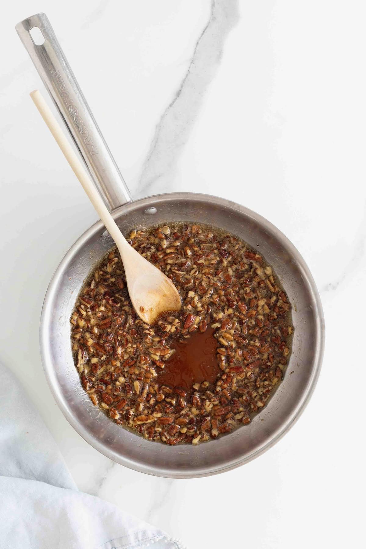 A stainless steel skillet of toasted pecan maple syrup.