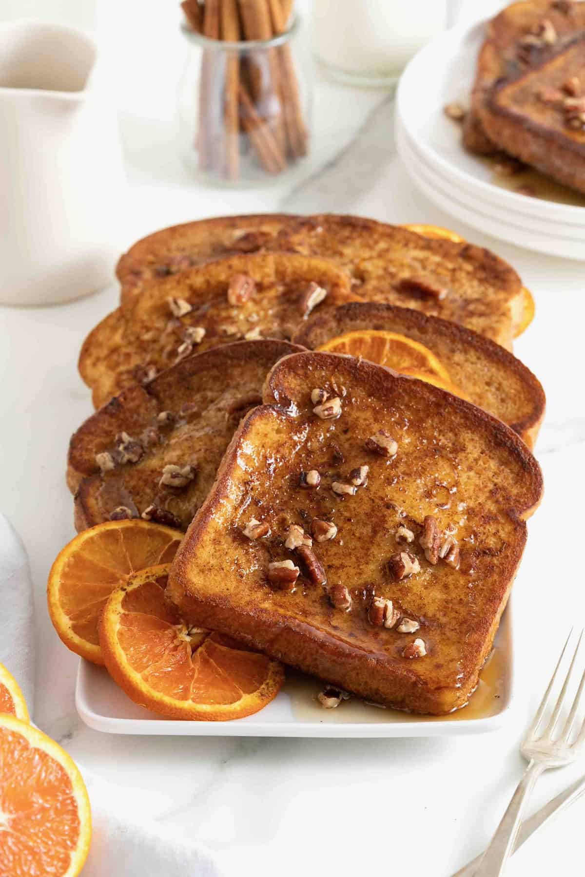 Orange pecan baked French toast on a white rectangular serving platter.