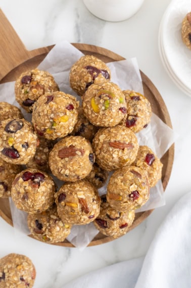 A pile of quinoa trail mix bites on a parchment lined wooden serving platter.