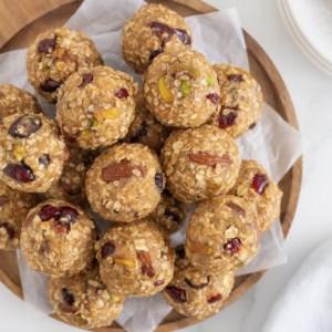 Trail mix bites on a sheet of parchment paper on a wooden platter.