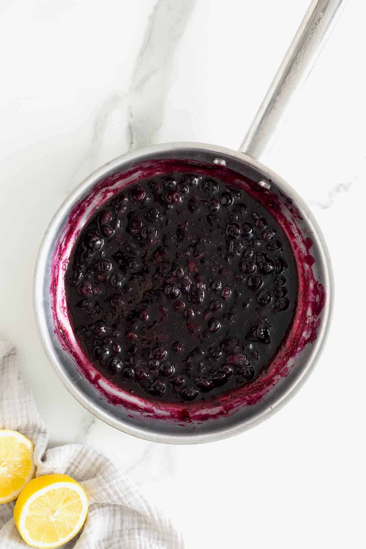 Blueberry syrup in a metal sauce pan.
