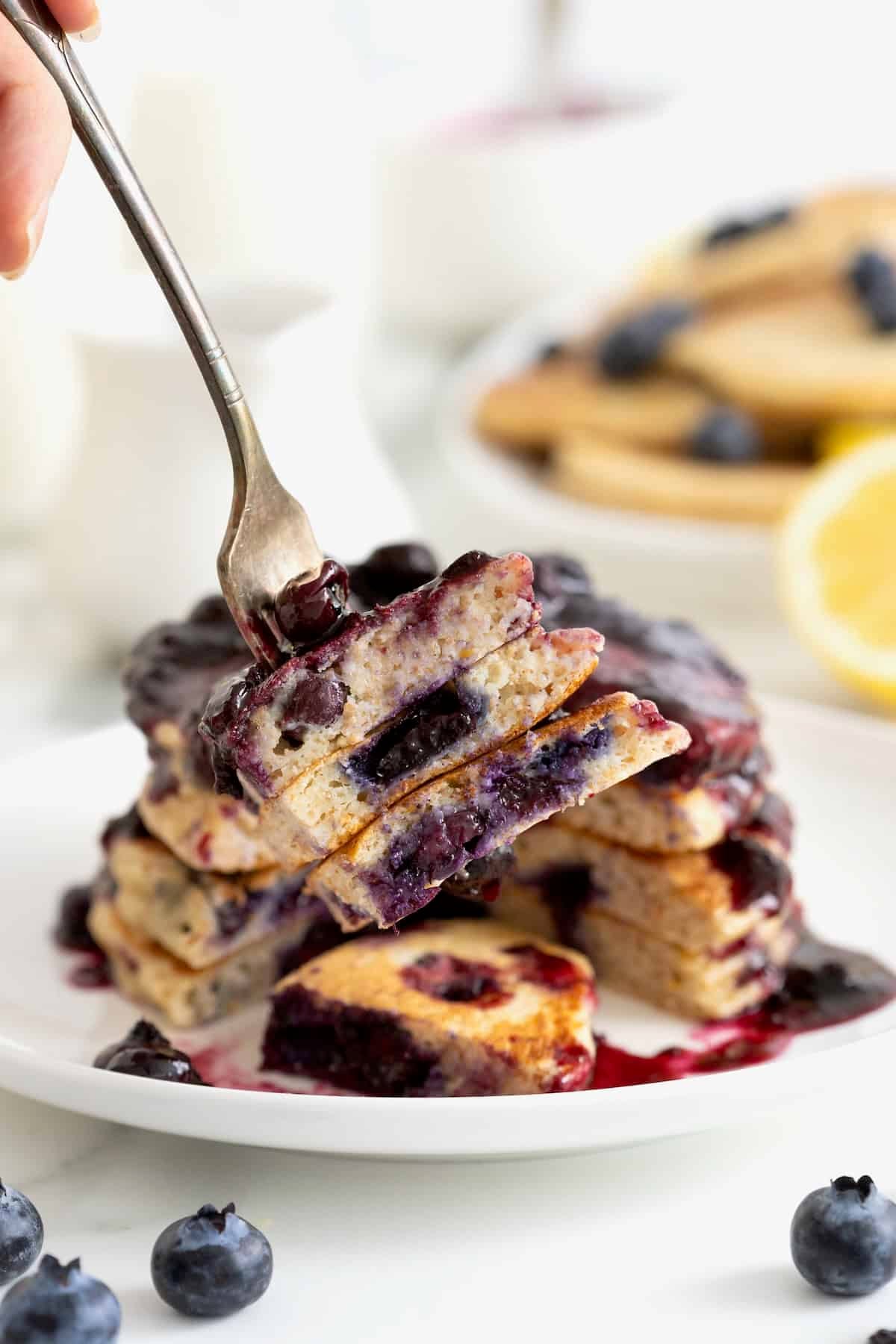 A bite of blueberry lemon ricotta pancake on a metal fork.