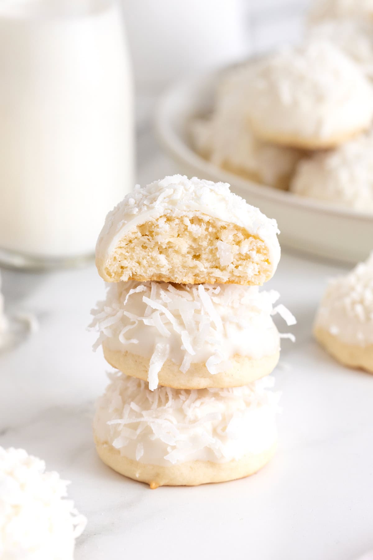 A stack of three coconut cookies dipped in white chocolate.