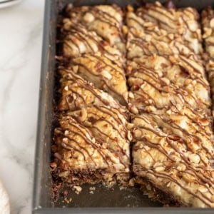 A dark aluminum baking pan of Nutella Baklava. One piece is missing from the bottom left corner.