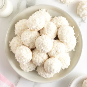 A platter of cookies coated in white chocolate and coconut.