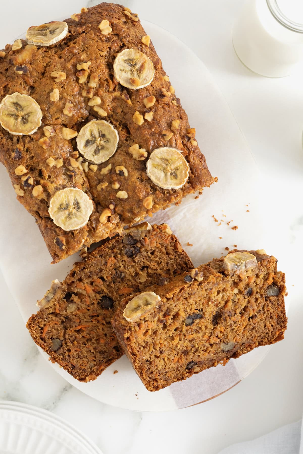 A loaf of whole wheat banana nut carrot cake bread on a white surface.