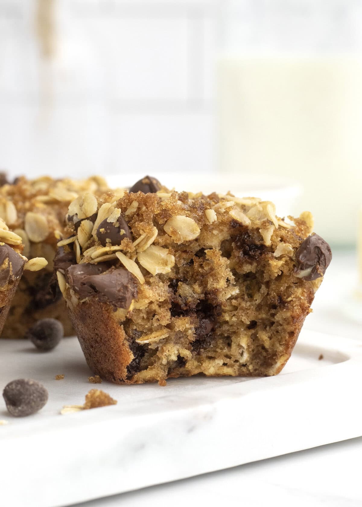 An oatmeal chocolate chip muffin with a bite taken out of it.