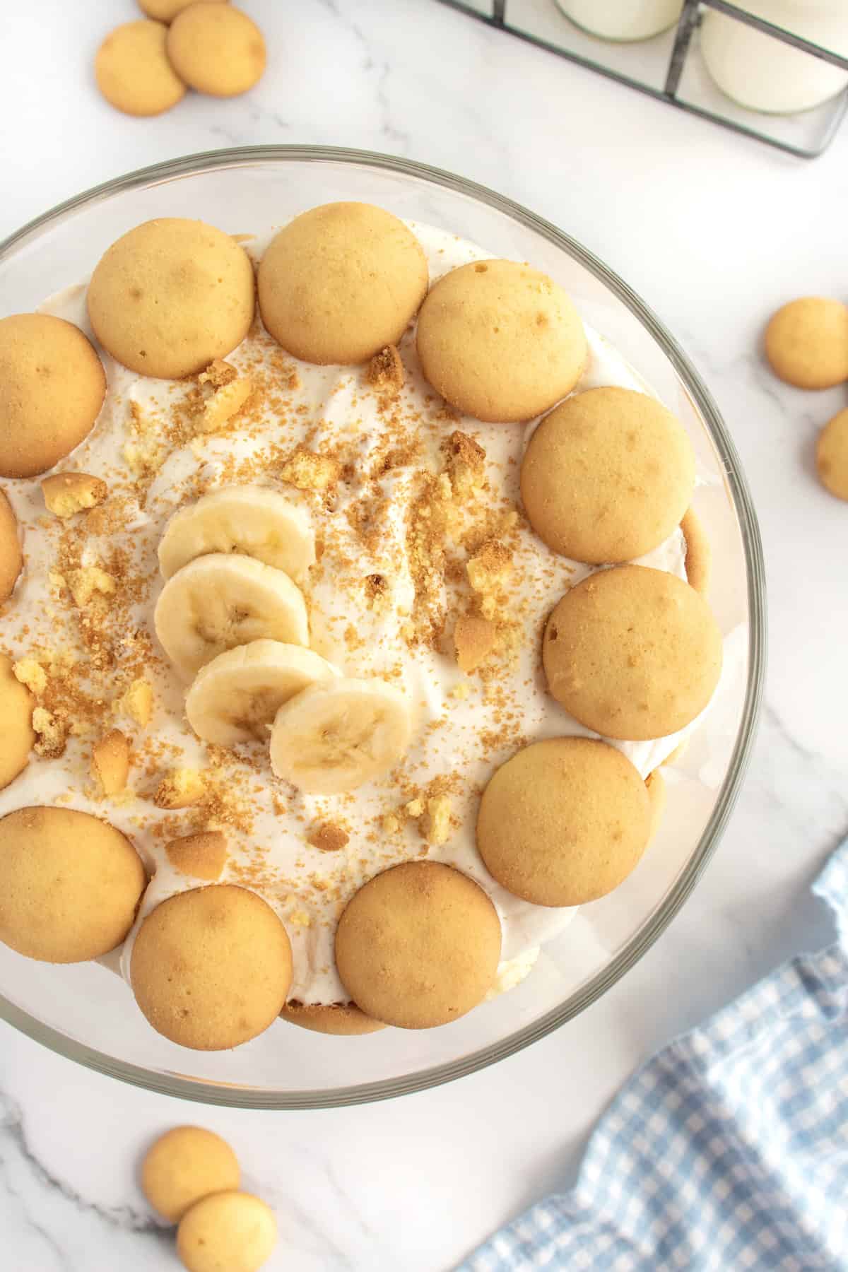 A large container of banana pudding topped with banana slices and vanilla wafers.
