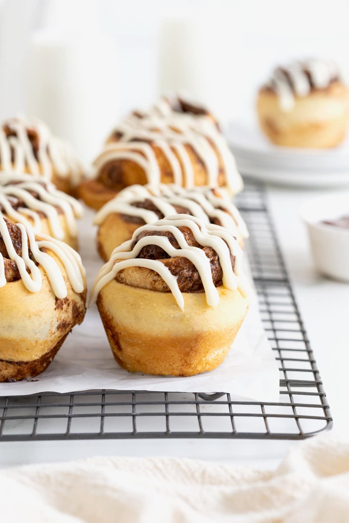 Six Nutella roll muffins on a parchment lined cooling rack. 