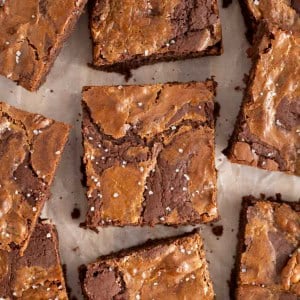 Salted dulce de leche brownies on a parchment lined surface.