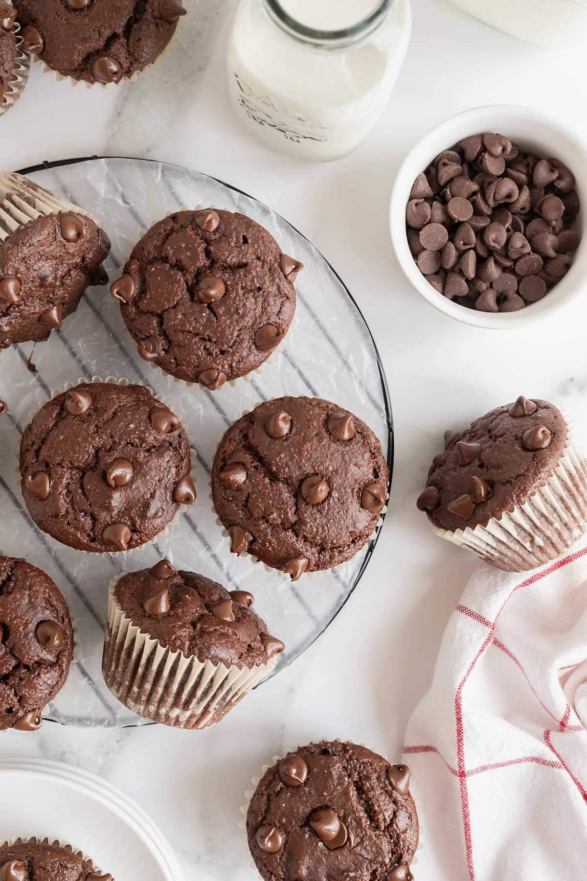 A round wire cooling rack scattered with chocolate muffins.