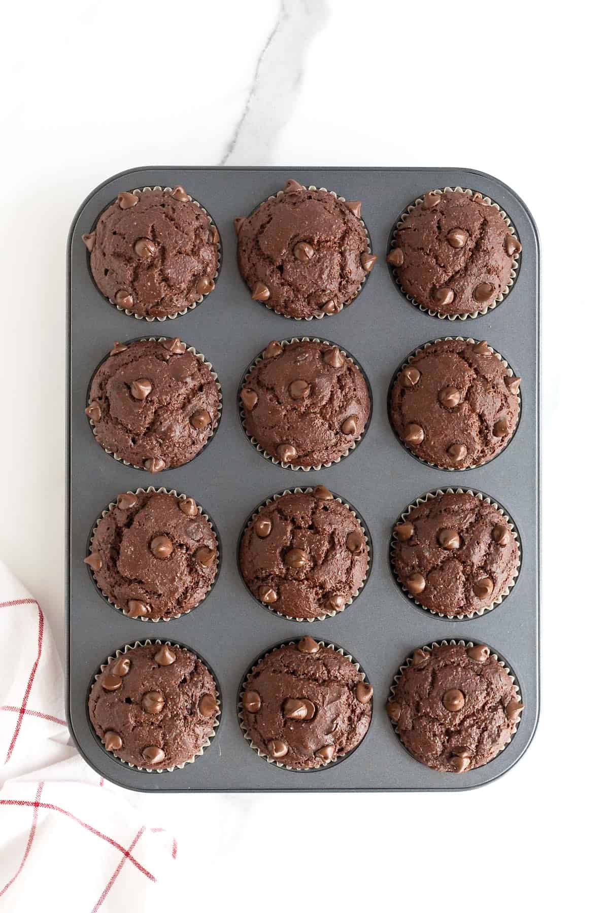 A dark aluminum muffin tin of double chocolate muffins.